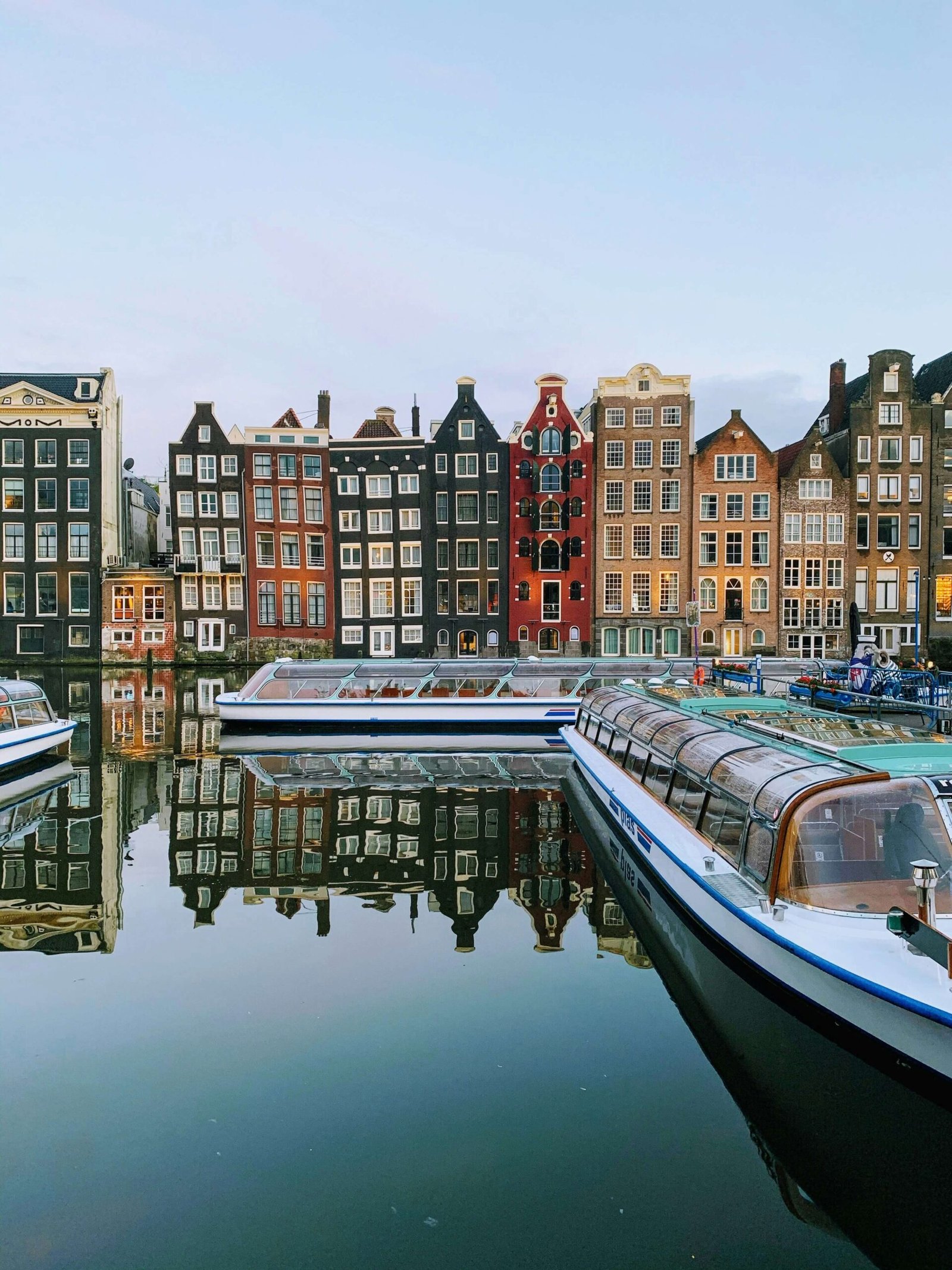 Amsterdam canal houses reflected in still water