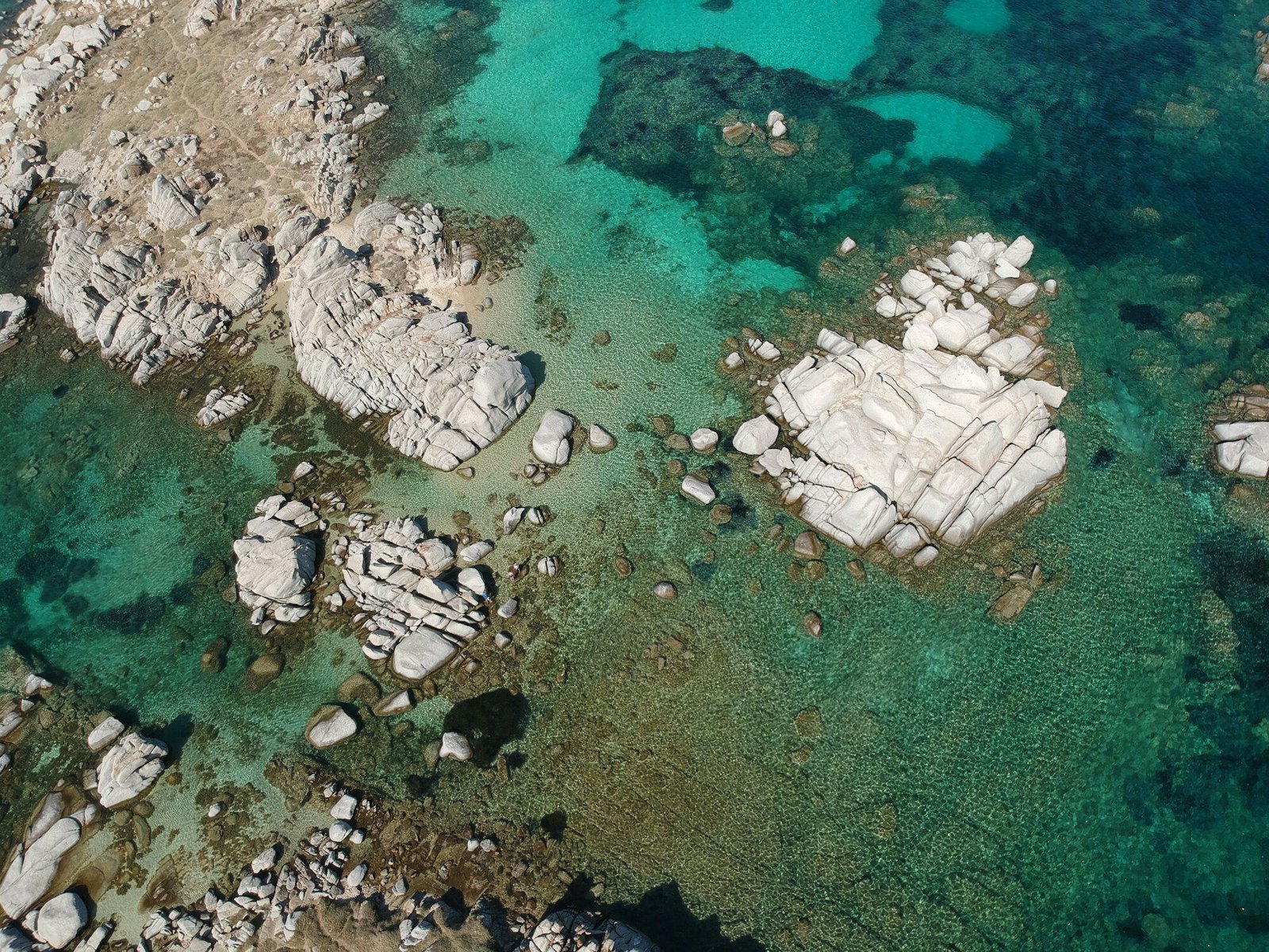 Clear turquoise water over pale granite rocks, aerial view, Lavezzi Islands