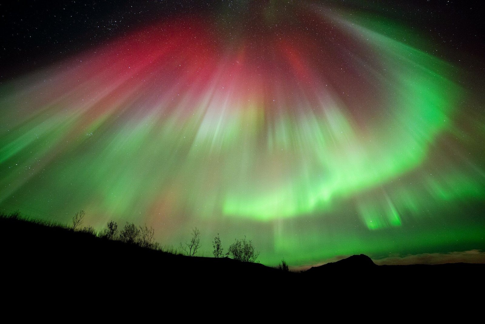 Northern lights over Lofoten, red and green aurora filling the night sky, minimal foreground elements
