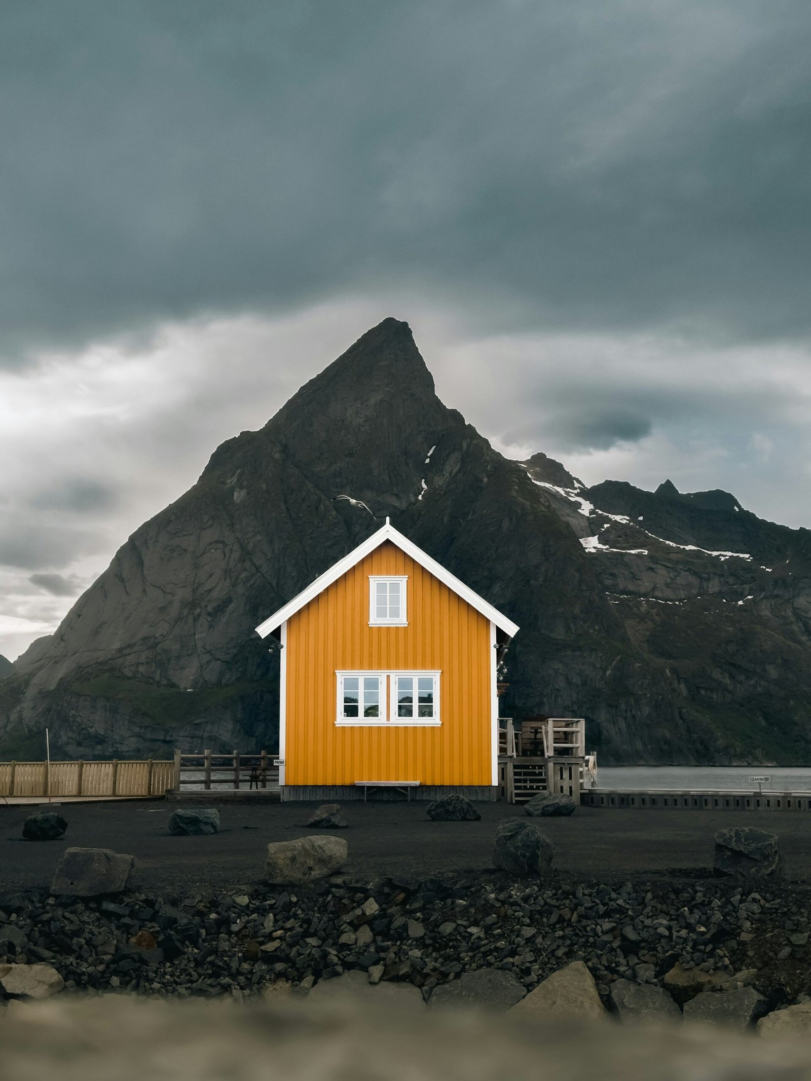 Yellow traditional house with mountain backdrop, Gimsoysand, Lofoten