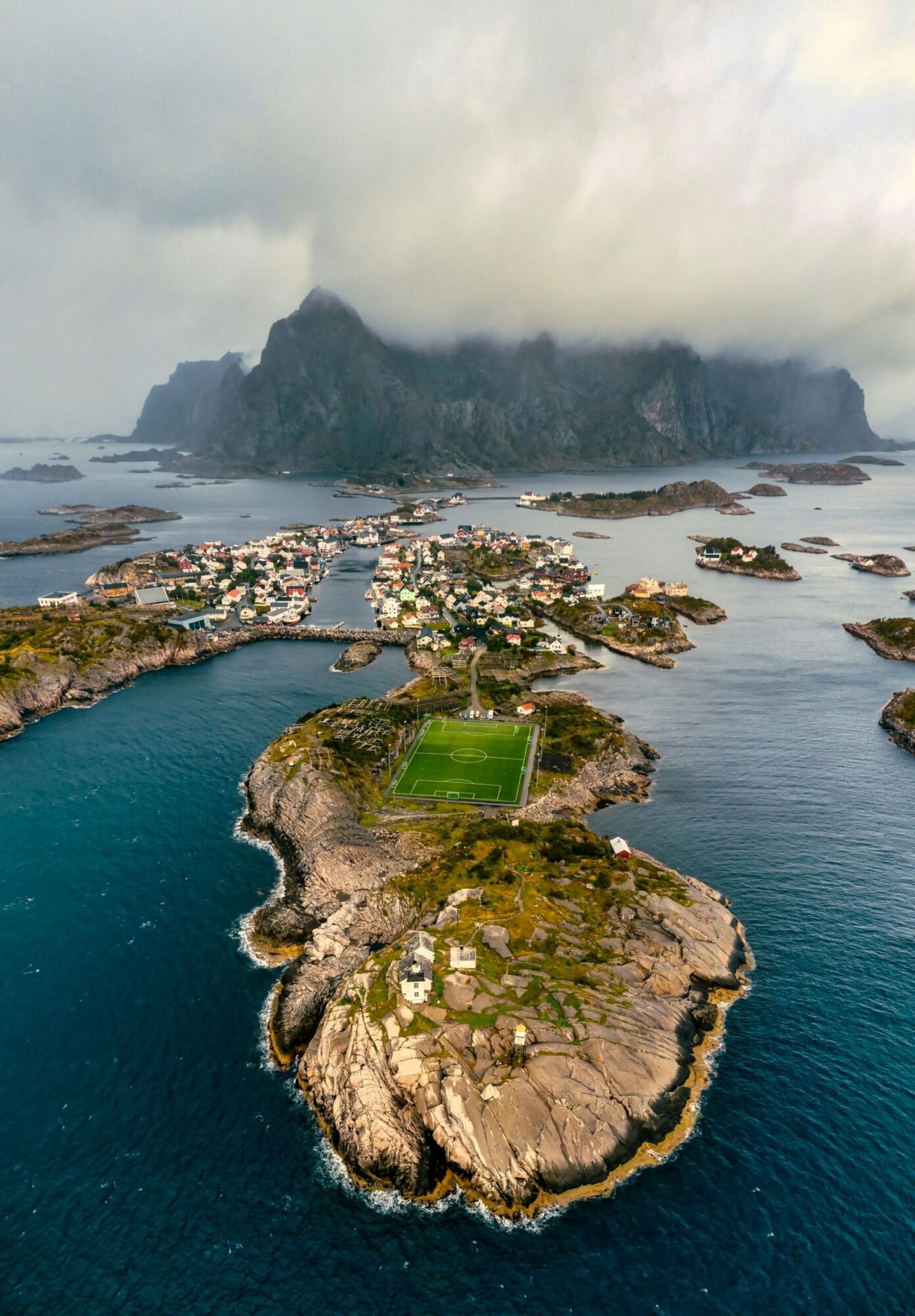 Aerial view of Henningsvaer, a working fishing harbour in Lofoten, colourful buildings on the water