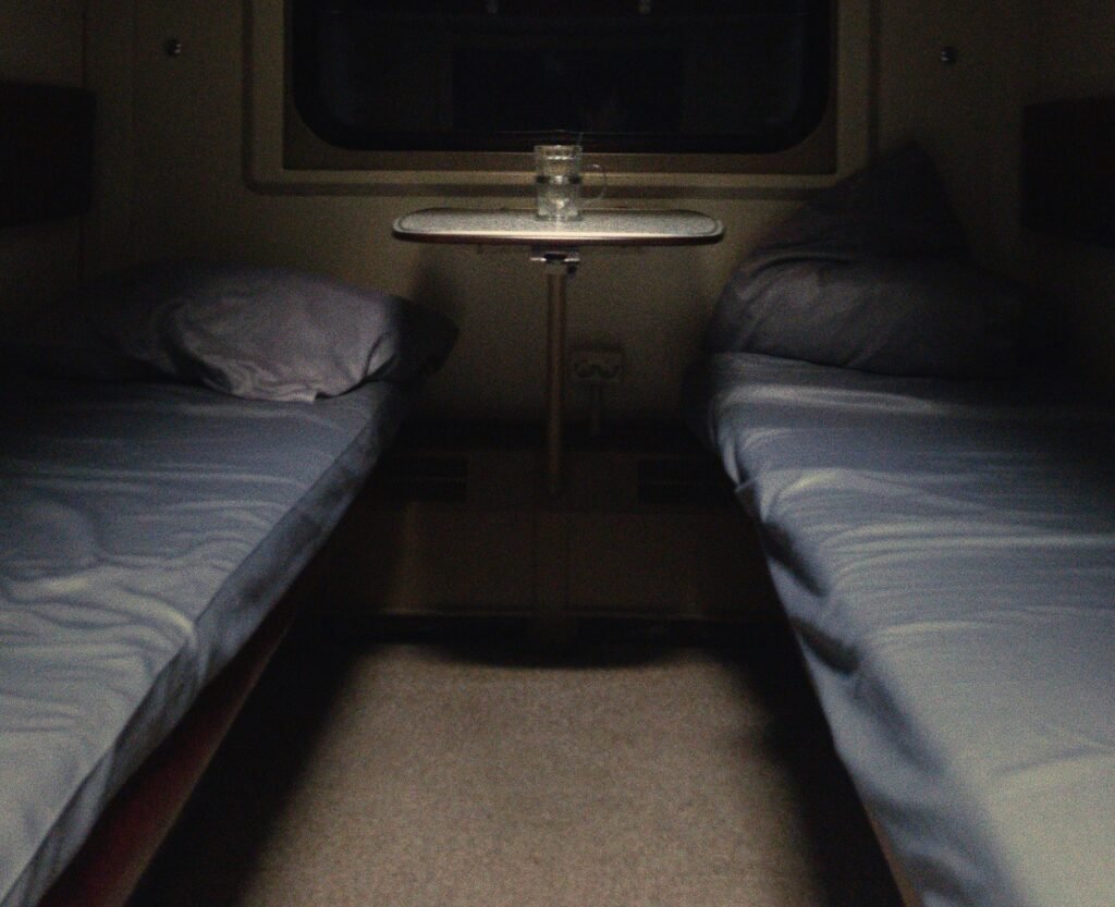 Berths made up for the night in a sleeper train compartment, small table and window