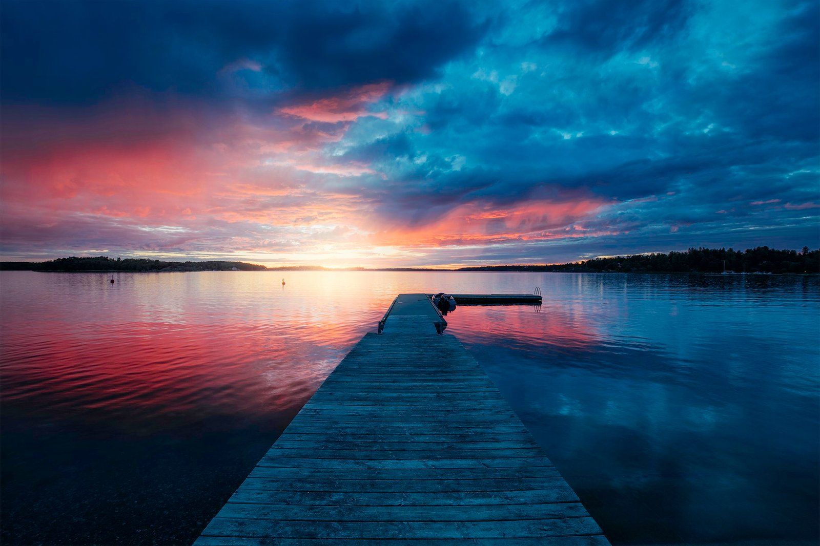 Wooden dock in the Stockholm archipelago at Varmdo, golden hour light on the water