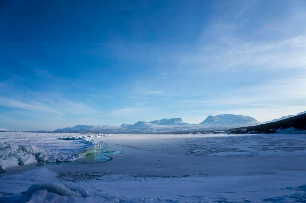 Frozen lake and snow-covered fells near Abisko, Swedish Lapland, in clear winter light